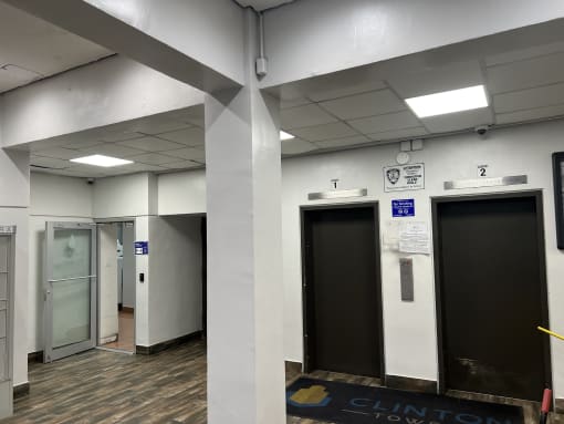 a hallway of elevators and doors in a building at Clinton Towers, Bronx, NY, 10457
