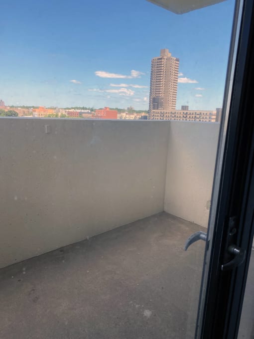a balcony with a blue sky and a city in the background at Clinton Towers, Bronx, NY