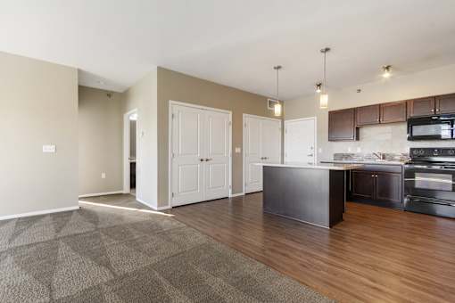 A kitchen with a black counter top and white cabinets.