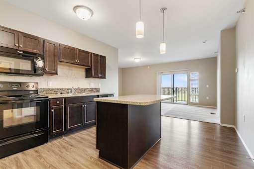 A kitchen with dark wood cabinets and a black oven.