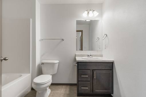A white toilet sits next to a sink in a bathroom.