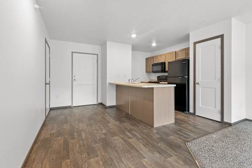 A kitchen with a refrigerator, microwave, and oven.
