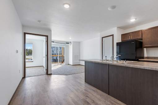 A modern kitchen with dark wood cabinets and a black fridge.