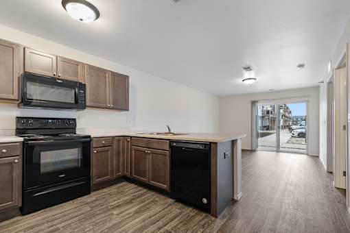 A kitchen with wooden cabinets and black appliances.