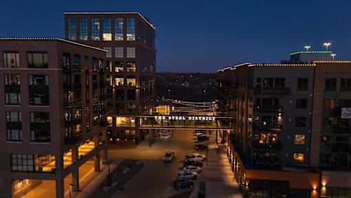 A view of a parking lot and buildings at night.