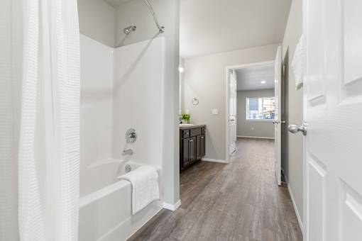 A white bathroom with a white tub and a white door.