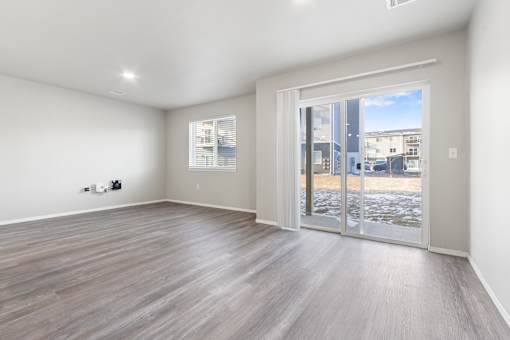 A room with a sliding glass door leading to a balcony.