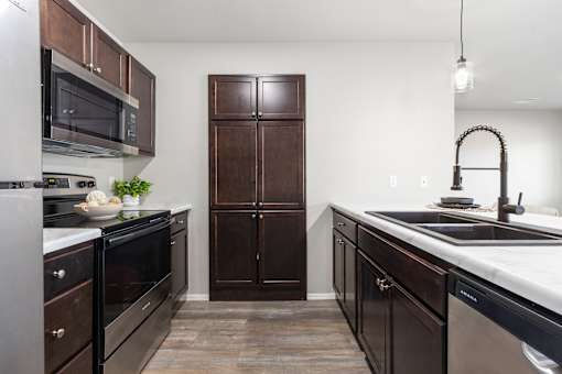 A kitchen with dark wood cabinets and stainless steel appliances.
