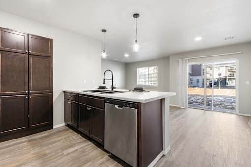 A modern kitchen with a large island and wooden floors.
