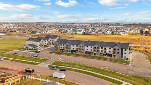 A large building complex with a parking lot in front.