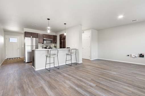 A kitchen with a white counter and bar stools.