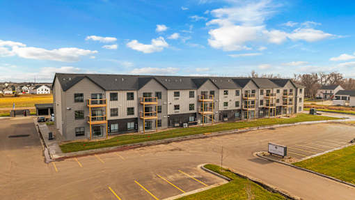 A large building complex with a parking lot in front.