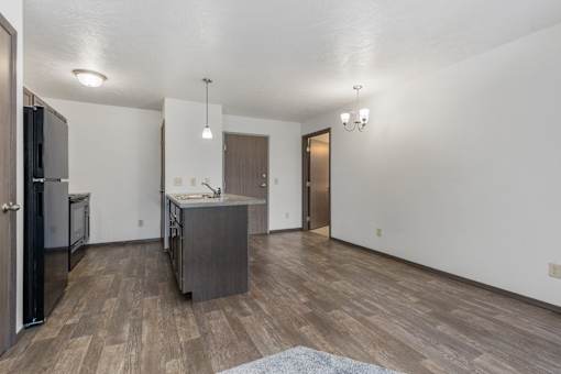 A kitchen with a refrigerator, sink, and cabinets.