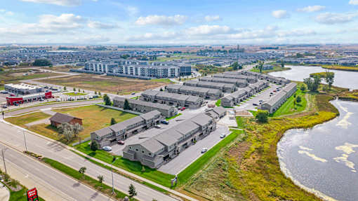 A large building complex is situated next to a body of water.