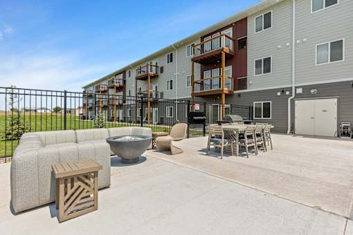our apartments have a large patio with furniture and a fire pit
