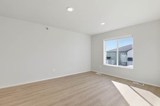 A room with a window and wooden flooring.