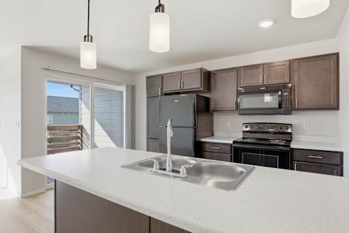 A modern kitchen with a large island and stainless steel appliances.