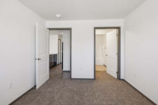A hallway with carpeted floors and white walls.