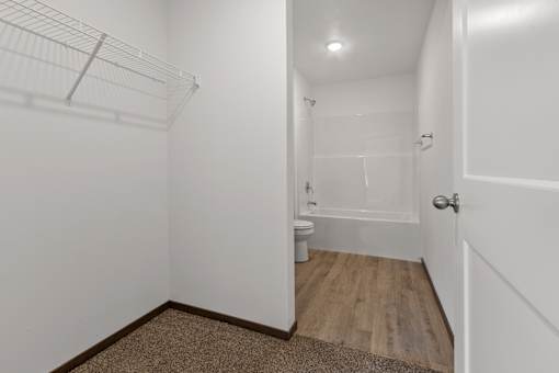 A white bathroom with a toilet and a walk-in shower.