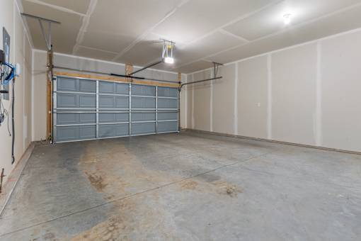 A large empty garage with a grey floor and white walls.