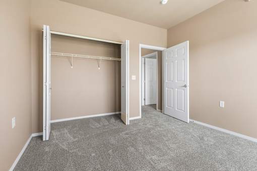 A room with a grey carpet and a white door.