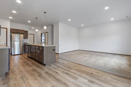 A modern kitchen with wooden floors and a large island.