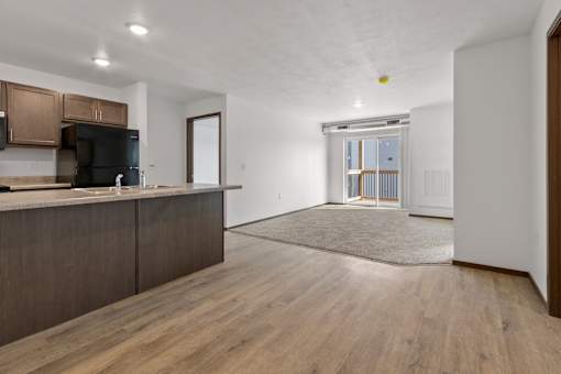 A kitchen with wooden cabinets and a black fridge.