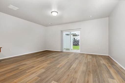 A room with wooden flooring and a sliding glass door.