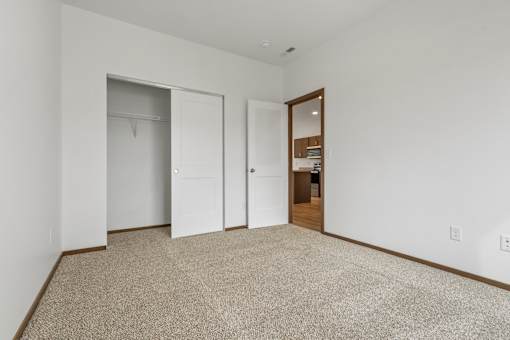A room with carpeted floor and three doors.