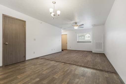 A room with a brown door and a ceiling fan.