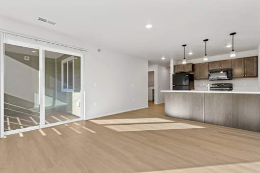 A modern kitchen with a white countertop and a wooden floor.