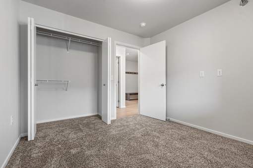 A room with a carpeted floor and a white door.