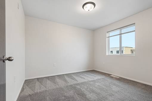 A room with a carpeted floor and a window.