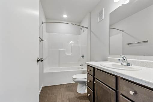 A bathroom with a toilet, sink, and a walk-in shower.