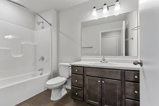 A bathroom with a white tub, sink, and toilet.