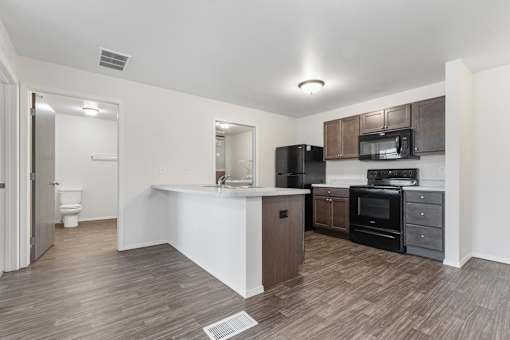 A kitchen with black appliances and a white counter.