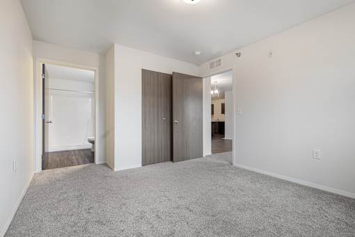 A spacious room with a carpeted floor and white walls.