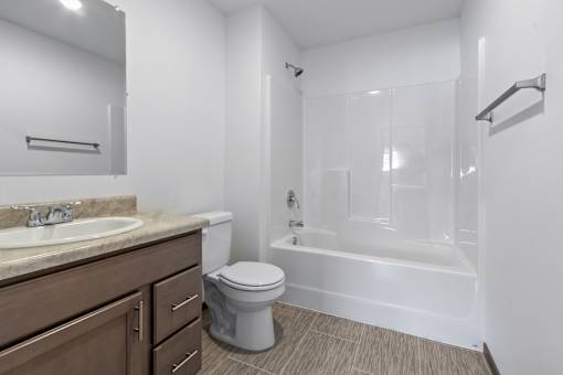 A white bathroom with a toilet, sink, and bathtub.
