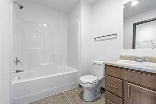 A white bathroom with a toilet, sink, and bathtub.