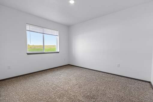 A room with a window overlooking a field.