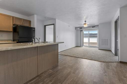 A kitchen with wooden cabinets and a black fridge.