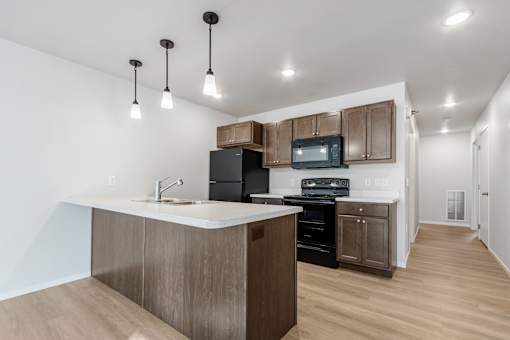A kitchen with a white counter top and wooden cabinets.