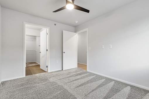 A room with a ceiling fan and a carpeted floor.