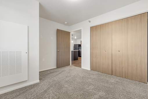 A room with a carpeted floor and wooden doors.