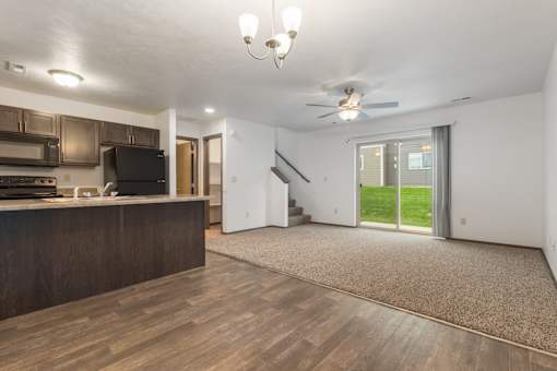 A spacious living room with a staircase leading to the upper floor.