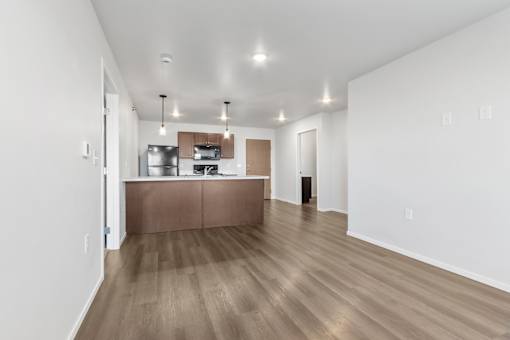 A kitchen with a wooden floor and white walls.