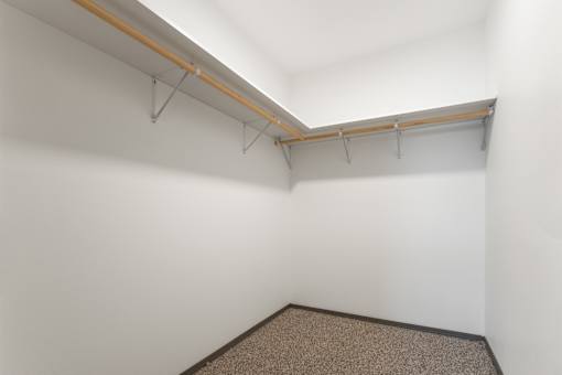 A room with a white wall and a brown carpet.