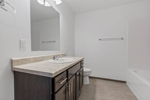 A bathroom with a sink, toilet, and bathtub.