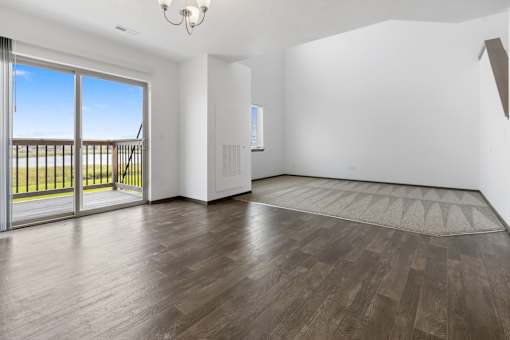 A room with a sliding glass door leading to a balcony.