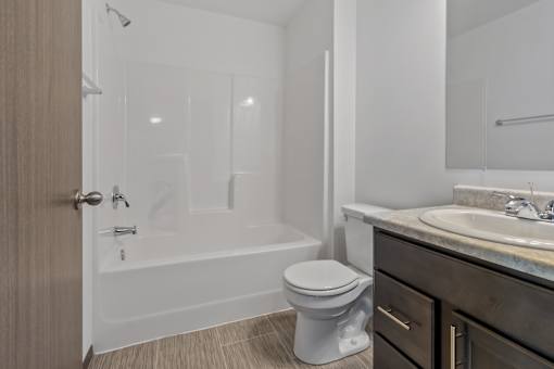 A white toilet sits in a bathroom next to a sink.